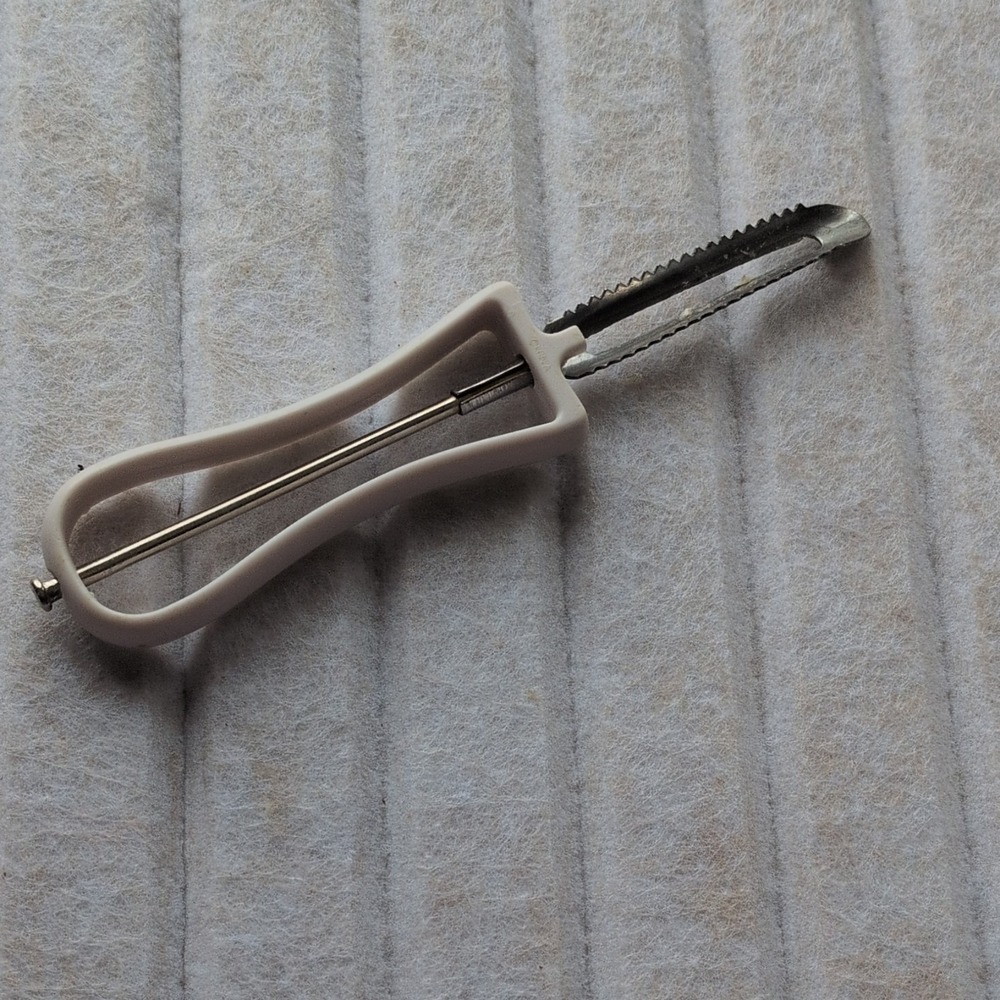 Manual Serrated Vegetable Peeler with‎ White Plastic Handle and Metal Blade